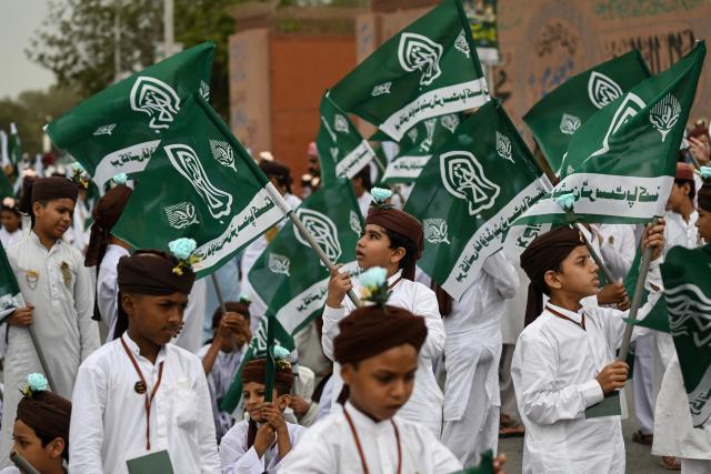 Sunni Muslim students from an Islamic seminary holding religious flags participate in a rally ahead of Eid-e-Milad-un-Nabi, which commemorates the birth anniversary of Prophet Muhammad, in Karachi on August 23, 2026. (Photo by Rizwan TABASSUM / AFP)