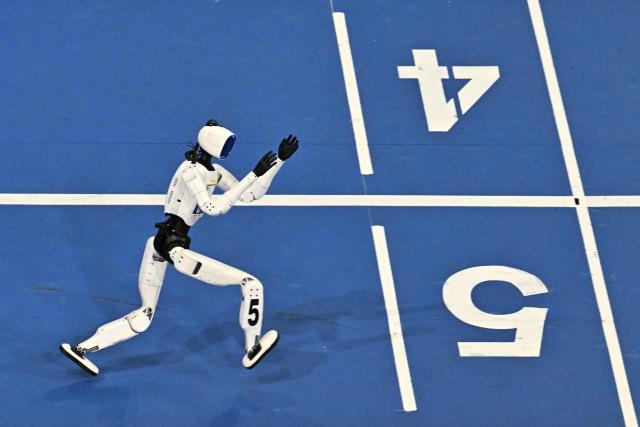 A humanoid robot competes in the 400-meter race on the second day of the 2nd World Humanoid Robot Games in Beijing on August 23, 2026. (Photo by Pedro PARDO / AFP)