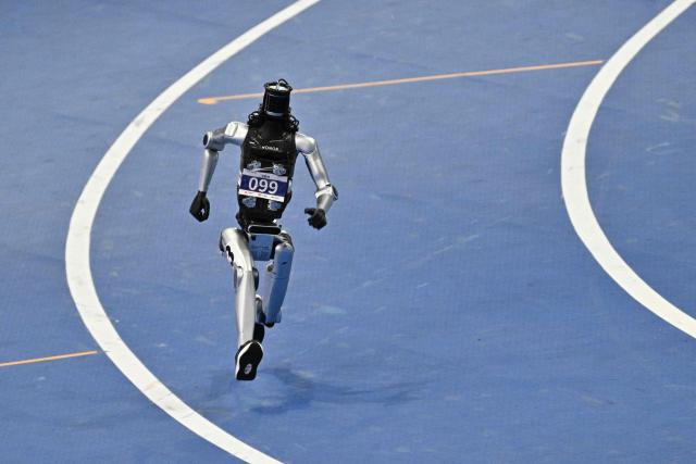 A humanoid robot competes in the 400-meter race on the second day of the 2nd World Humanoid Robot Games in Beijing on August 23, 2026. (Photo by Pedro PARDO / AFP)