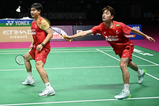 China's Wang Chang (R) and Liang Wei Keng play a point against Malaysia’s Aaron Chia and Soh Wooi Yik during the BWF World Championships men's doubles final badminton match at the Indira Gandhi Indoor Stadium in New Delhi on August 23, 2026. (Photo by Sajjad HUSSAIN / AFP)