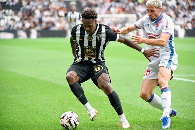 Angers' French defender #27 Lilian Raolisoa fights for the ball with Lille’s French defender #15 Romain Perraud during the French L1 football match between Angers SCO and LOSC Lille at the Stade Raymond Kopa in Angers, western France on August 23, 2026. (Photo by Sebastien Salom-Gomis / AFP)