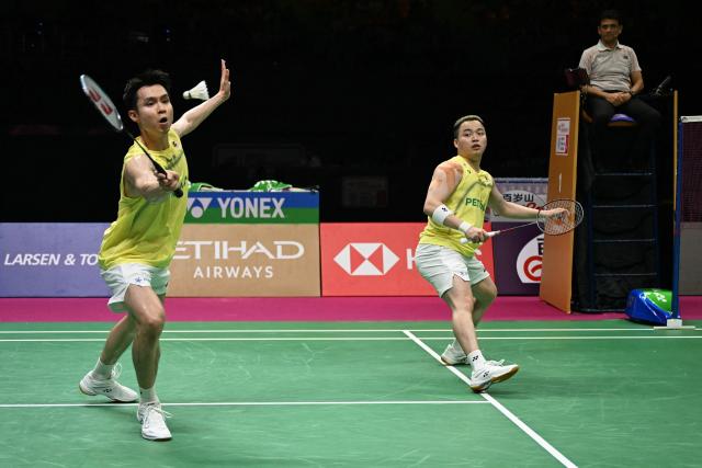 Malaysia’s Soh Wooi Yik (L) and Aaron Chia plays a point against China's Liang Wei Keng and Wang Chang during the BWF World Championships men's doubles final badminton match at the Indira Gandhi Indoor Stadium in New Delhi on August 23, 2026. (Photo by Sajjad HUSSAIN / AFP)