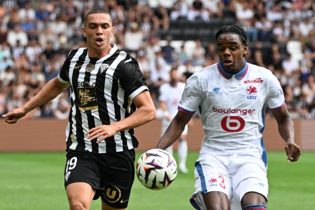 Angers' Moroccan forward #19 Amine EL Ouazzani fights for the ball with Lille’s Belgian defender #3 Nathan Ngoy during the French L1 football match between Angers SCO and LOSC Lille at the Stade Raymond Kopa in Angers, western France on August 23, 2026. (Photo by Sebastien Salom-Gomis / AFP)