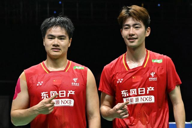 China's Liang Wei Keng (L) and Wang Chang celebrate winning the BWF World Championships men's doubles final badminton match against Malaysia’s Aaron Chia and Soh Wooi Yik at the Indira Gandhi Indoor Stadium in New Delhi on August 23, 2026. (Photo by Sajjad HUSSAIN / AFP)