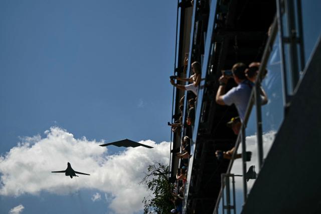 Spectators watch a flyover from military aircraft before the start of the IndyCar Freedom 250 Grand Prix in Washington, DC, on August 23, 2026. The Freedom 250 Grand Prix is part of celebrations marking the 250th anniversary of US independence. The race will cover 147 laps of a 1.7-mile, seven-turn street circuit around the National Mall, passing landmarks including the US Capitol and Washington Monument. (Photo by Kent NISHIMURA / AFP)