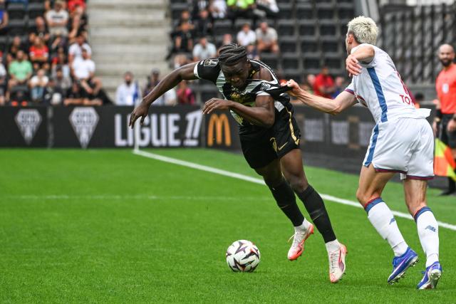 Angers' Cameroonian forward #11 Djibirin Harouan (L) is tackled by Lille’s French defender #15 Romain Perraud (R) as they fight for the ballduring the French L1 football match between Angers SCO and LOSC Lille at the Stade Raymond Kopa in Angers, western France on August 23, 2026. (Photo by Sebastien Salom-Gomis / AFP)