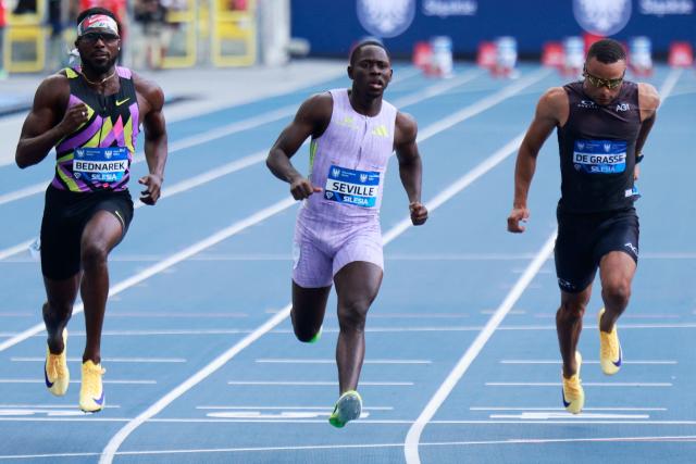 Jamaica's Oblique Seville (C) competes to win followed by Canada's Andre de Grasse (R) and US' Kenneth Bednarek (L) in the men's 100 m event at the Silesia Diamond League athletics meeting in Katowice, Poland, on August 23, 2026. (Photo by Wojtek RADWANSKI / AFP)