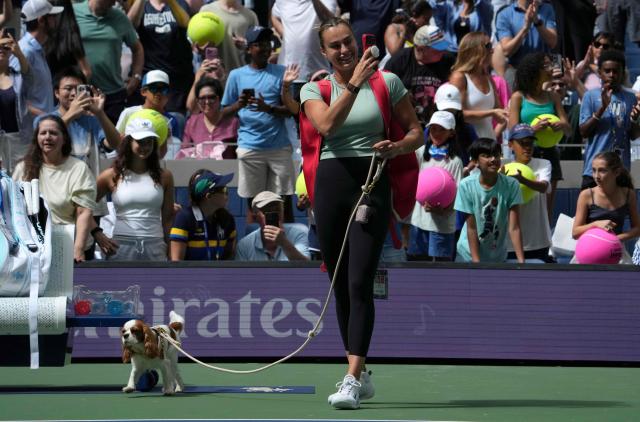 World number One Aryna Sabalenka walks onto the court with her dog Ash for a practice session during Arthur Ashe Kids' Day on August 23, 2026 as part of US Open Fan Week events at the USTA Billie Jean King National Tennis Center in New York. (Photo by TIMOTHY A. CLARY / AFP)