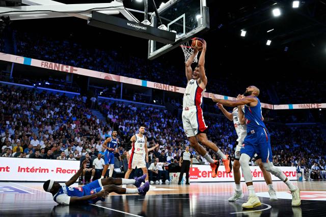 Serbia's #02 Nemanja Dangubic (C) slam dunks to the basket during the friendly basketball match between France and Serbia, at the CO'Met Arena in Orleans, north-central France on August 23, 2026. (Photo by LOU BENOIST / AFP)