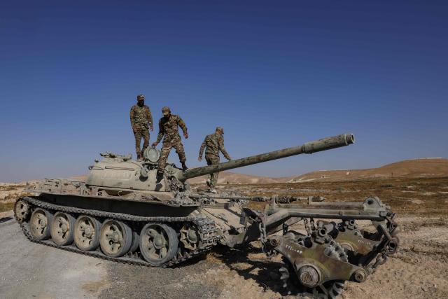 Syrian army soldiers stand on the chassis of a mine-clearing tank of the Syrian Ministry of Defence's military engineering department during a demining operation in Qarah in the Damascus countryside on August 23, 2026. (Photo by Bakr ALkasem / AFP)
