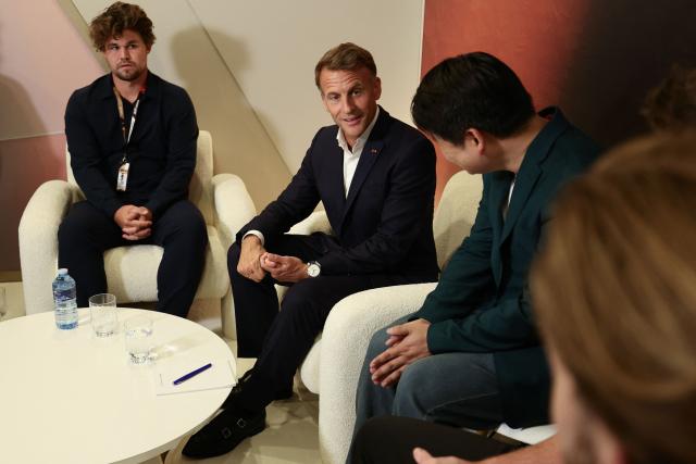 France's President Emmanuel Macron ((C) and Norwegian chess grandmaster Magnus Carlsen (L) attend the closing ceremony of the Esports World Cup at the Grand Palais in Paris, on August 23, 2026. (Photo by Teresa SUAREZ / POOL / AFP)