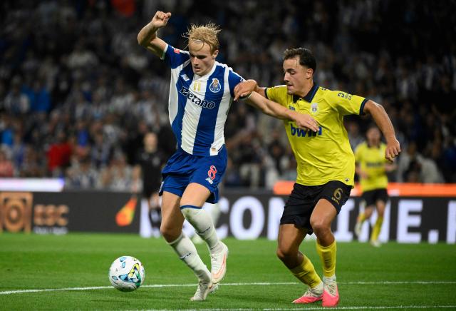 FC Porto's Danish midfielder #08 Victor Froholdt fights for the ball with Arouca's Dutch midfielder #06 Espen van Ee during the Portuguese League football match between FC Porto and FC Arouca at Dragao stadium in Porto, on August 23, 2026. (Photo by Miguel RIOPA / AFP)