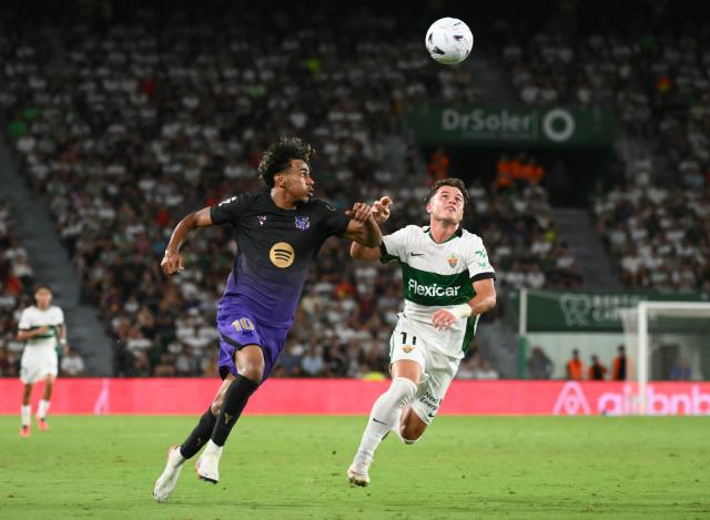 Barcelona's Spanish forward #10 Lamine Yamal fights for the ball with Elche's Spanish forward #11 German Valera during the Spanish league football match between Elche CF and FC Barcelona at Martinez Valero Stadium in Elche on August 23, 2026. (Photo by JOSE JORDAN / AFP)