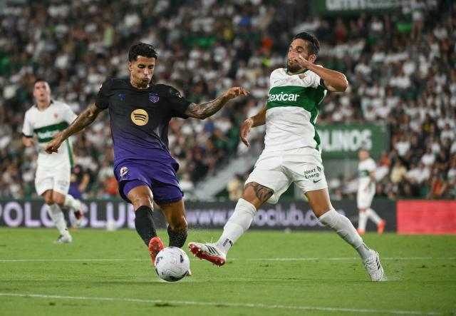 Barcelona's Portuguese defender #02 Joao Cancelo fights for the ball with Elche's Spanish defender #06 Pedro Bigas Rigo during the Spanish league football match between Elche CF and FC Barcelona at Martinez Valero Stadium in Elche on August 23, 2026. (Photo by JOSE JORDAN / AFP)