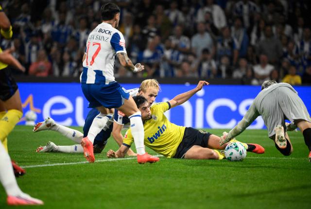 FC Porto's Danish midfielder #08 Victor Froholdt challenges Arouca's Uruguayan goalkeeper #12 Ignacio De Arruabarrena during the Portuguese League football match between FC Porto and FC Arouca at Dragao stadium in Porto, on August 23, 2026. (Photo by Miguel RIOPA / AFP)