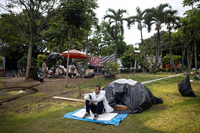 A man affected by the 7.4-magnitude earthquake that struck Colombia on August 19 takes shelter in a makeshift camp set up in a park in Pereira, Risaralda department, Colombia on August 23, 2026. The powerful earthquake that killed hundreds of people in western Colombia caused $9.57 billion in economic losses, President Abelardo de la Espriella said on August 18, issuing a preliminary estimate. (Photo by Esteban Vega La-Rotta / AFP)