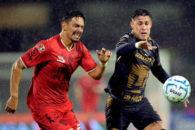 Necaxa's forward #30 Ricardo Monreal and Pumas' defender #12 Cristian Calderon fight for the ball during the Liga MX Apertura tournament football match between Pumas and Necaxa at the Olimpico Universitario stadium in Mexico City on August 23, 2026. (Photo by Alfredo ESTRELLA / AFP)