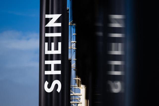 (FILES) This photograph shows the logo of Asian e-commerce giant Shein on the facade of the Bazar de l'Hotel de Ville (BHV) department store in Paris on November 3, 2025, just days before it opens its first physical store at BHV in Paris. Shein will debut on the Hong Kong stock exchange on September 1, seeking to raise US$1.7 billion from the long-awaited listing, the fast-fashion giant said on August 24, 2026. (Photo by Julie SEBADELHA / AFP)