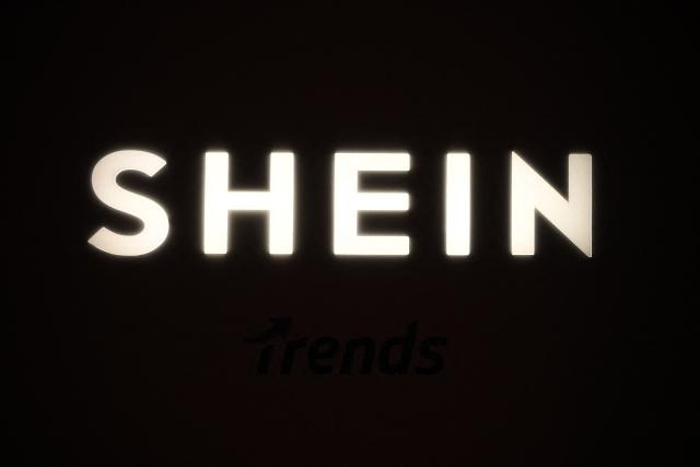 (FILES) A picture shows the logo Shein during the Urban Ritual fashion show Fall-Winter 2025/26 organized by Chinese fashion giant Shein in Milan, on October 16, 2025. Shein will debut on the Hong Kong stock exchange on September 1, seeking to raise US$1.7 billion from the long-awaited listing, the fast-fashion giant said on August 24, 2026. (Photo by Piero CRUCIATTI / AFP)