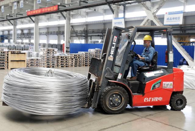 A worker operates a forklift to move aluminum-titanium-boron, a core auxiliary material for aluminum-based products, at Anhui Dongbo Shengye New Materials Technology in Huaibei, eastern China's Anhui province on August 22, 2026. (Photo by CN-STR / AFP) / China OUT