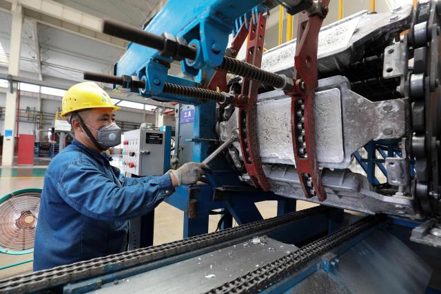 A worker operates a machine on the production line of aluminum-titanium-boron, a core auxiliary material for aluminum-based products, at Anhui Dongbo Shengye New Materials Technology in Huaibei, eastern China's Anhui province on August 22, 2026. (Photo by CN-STR / AFP) / China OUT