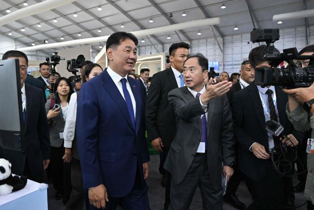Mongolia's President Ukhnaagiin Khurelsukh (L) visits the delegation pavillion during the 17th Session of the Conference of the Parties (COP17) of the United Nations Convention to Combat Desertification (UNCCD) at the venue in Ulaanbaatar on August 24, 2026. (Photo by Hector RETAMAL / AFP)