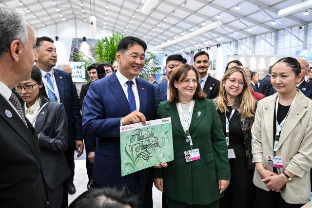 Mongolia's President Ukhnaagiin Khurelsukh (centre L) visits the delegation pavilion during the 17th Session of the Conference of the Parties (COP17) of the United Nations Convention to Combat Desertification (UNCCD) in Ulaanbaatar on August 24, 2026. (Photo by Hector RETAMAL / AFP)