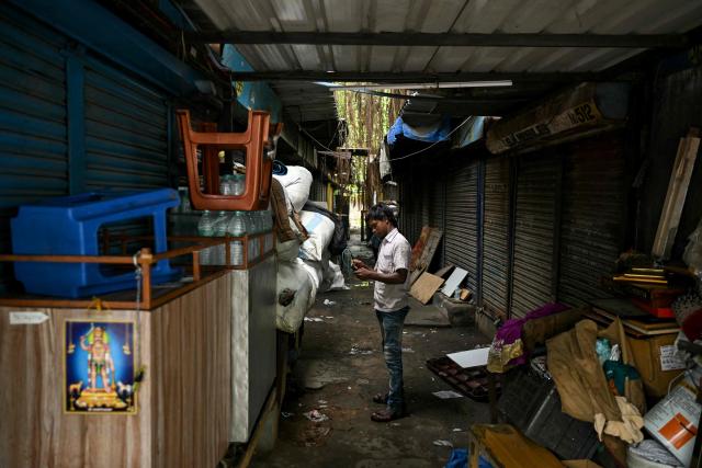 A man stands near closed shops early morning in Chennai on August 24, 2026. (Photo by R. Satish BABU / AFP)