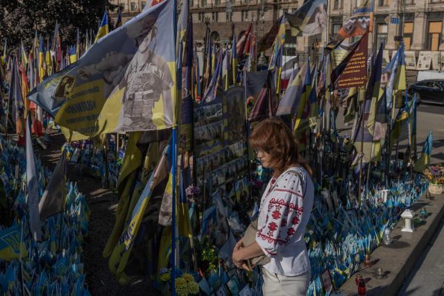 A woman visits the makeshift memorial for fallen Ukrainian and foreign soldiers during the Independence Day of Ukraine, on Independence Square in Kyiv on August 24, 2026, amid the Russian invasion of Ukraine. (Photo by Roman PILIPEY / AFP)