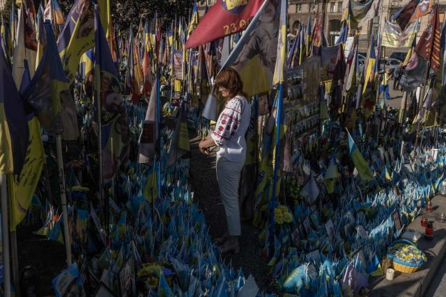 A woman visits the makeshift memorial for fallen Ukrainian and foreign soldiers during the Independence Day of Ukraine, on Independence Square in Kyiv on August 24, 2026, amid the Russian invasion of Ukraine. (Photo by Roman PILIPEY / AFP)