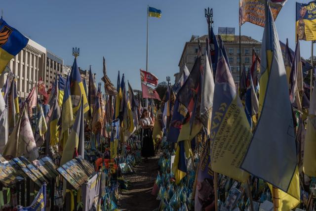A woman visits the makeshift memorial for fallen Ukrainian and foreign soldiers during the Independence Day of Ukraine, on Independence Square in Kyiv on August 24, 2026, amid the Russian invasion of Ukraine. (Photo by Roman PILIPEY / AFP)
