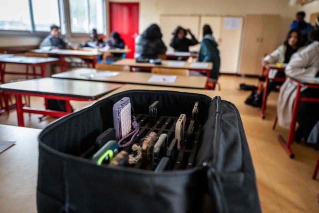 (FILES) This photo shows a suitcase containing students' mobile phones, set aside during classes at the Jean Mermoz vocational high school in Montsoult, in the northern suburbs of Paris, on January 14, 2026. The ban on mobile phones in high schools "could take effect as early as the start of the school year" next week, government spokesperson Maud Bregeon announced on August 24, 2026. (Photo by BERTRAND GUAY / AFP)