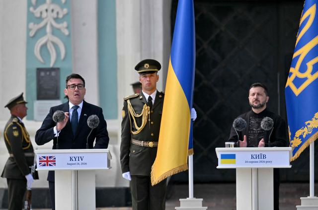 Britain's prime minister Andy Burnham (L) delivers a speech next to President Volodymyr Zelensky (R)  during a commemorative ceremony marking Ukraine's 35th Independence Day outside St. Sofia cathedral in Kyiv on August 24, 2026. Ukraine hosts a meeting of its key European backers on August 24 to press for critical air-defence supplies and more pressure on Moscow, with Russian attacks killing more civilians than at any time since the first months of the invasion. The leaders of Luxembourg, Moldova, Estonia and EU Council President Antonio Costa are also in Kyiv for the talks hosted on Ukraine's Independence Day and which come amid the war's latest escalation. (Photo by Sergei SUPINSKY / AFP)