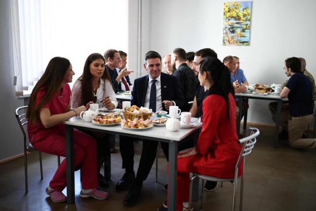 Britain's prime minister Andy Burnham (C) talks to hospital senior staff members upon arrival at the Main Military Hospital, supported by the David Nott Foundation, a UK charity who have trained over 1,000 Ukrainian surgeons, anaesthetists and other healthcare workers, in Kyiv on August 24, 2026. Ukraine hosts a meeting of its key European backers on August 24 to press for critical air-defence supplies and more pressure on Moscow, with Russian attacks killing more civilians than at any time since the first months of the invasion. The leaders of Luxembourg, Moldova, Estonia and EU Council President Antonio Costa are also in Kyiv for the talks hosted on Ukraine's Independence Day and which come amid the war's latest escalation. (Photo by Henry NICHOLLS / POOL / AFP)