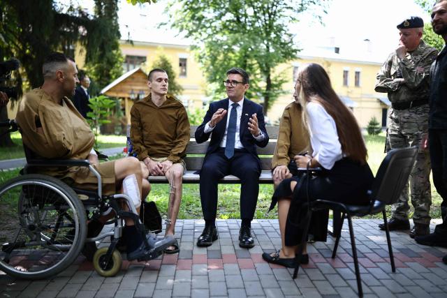 Britain's prime minister Andy Burnham (C) meets patients wounded in the war at the Main Military Hospital, supported by the David Nott Foundation, a UK charity who have trained over 1,000 Ukrainian surgeons, anaesthetists and other healthcare workers, in Kyiv on August 24, 2026. Ukraine hosts a meeting of its key European backers on August 24 to press for critical air-defence supplies and more pressure on Moscow, with Russian attacks killing more civilians than at any time since the first months of the invasion. The leaders of Luxembourg, Moldova, Estonia and EU Council President Antonio Costa are also in Kyiv for the talks hosted on Ukraine's Independence Day and which come amid the war's latest escalation. (Photo by Henry NICHOLLS / POOL / AFP)