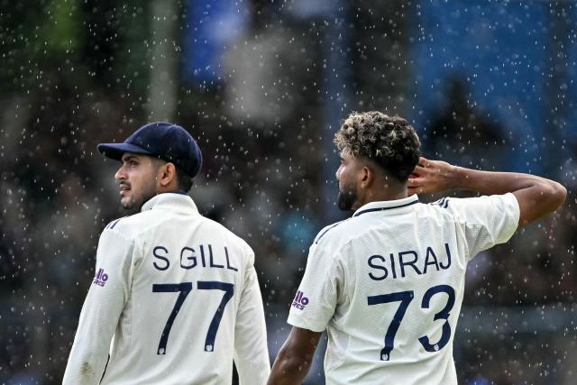 India's captain Shubman Gill (L) and teammate Mohammed Siraj walk back to the pavilion after rain stops the play during the second day of the second Test cricket match between Sri Lanka and India at the Sinhalese Sports Club Ground in Colombo on August 24, 2026. (Photo by Ishara S. KODIKARA / AFP)