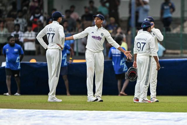 India's Yashasvi Jaiswal (C) speaks with his captain Shubman Gill (L) as they walk back to the pavilion after rain stops the play during the second day of the second Test cricket match between Sri Lanka and India at the Sinhalese Sports Club Ground in Colombo on August 24, 2026. (Photo by Ishara S. KODIKARA / AFP)