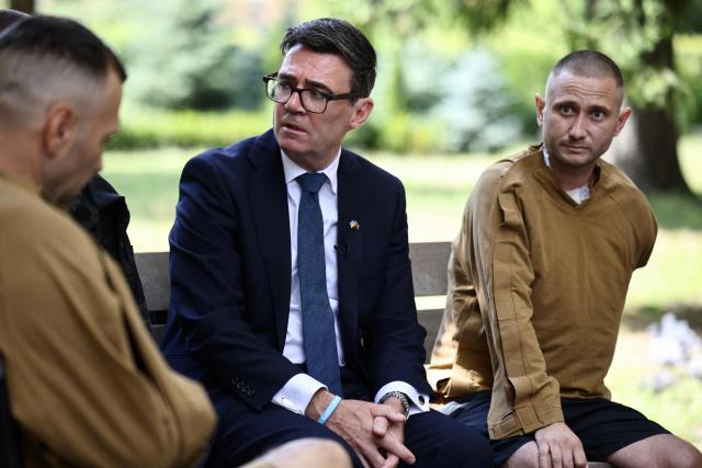 Britain's prime minister Andy Burnham (C) meets patients wounded in the war at the Main Military Hospital, supported by the David Nott Foundation, a UK charity who have trained over 1,000 Ukrainian surgeons, anaesthetists and other healthcare workers, in Kyiv on August 24, 2026. Ukraine hosts a meeting of its key European backers on August 24 to press for critical air-defence supplies and more pressure on Moscow, with Russian attacks killing more civilians than at any time since the first months of the invasion. The leaders of Luxembourg, Moldova, Estonia and EU Council President Antonio Costa are also in Kyiv for the talks hosted on Ukraine's Independence Day and which come amid the war's latest escalation. (Photo by Henry NICHOLLS / POOL / AFP)