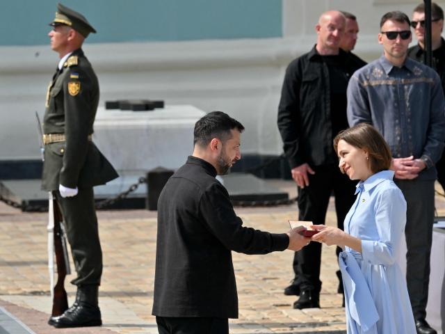 Moldova's President Maia Sandu (R) receives Ukrainian state award from Ukraine's President Volodymyr Zelensky during a commemorative ceremony marking Ukraine's 35th Independence Day outside St. Sofia cathedral in Kyiv on August 24, 2026. Ukraine hosts a meeting of its key European backers on August 24 to press for critical air-defence supplies and more pressure on Moscow, with Russian attacks killing more civilians than at any time since the first months of the invasion. The leaders of Luxembourg, Moldova, Estonia and EU Council President Antonio Costa are also in Kyiv for the talks hosted on Ukraine's Independence Day and which come amid the war's latest escalation. (Photo by Sergei SUPINSKY / AFP)
