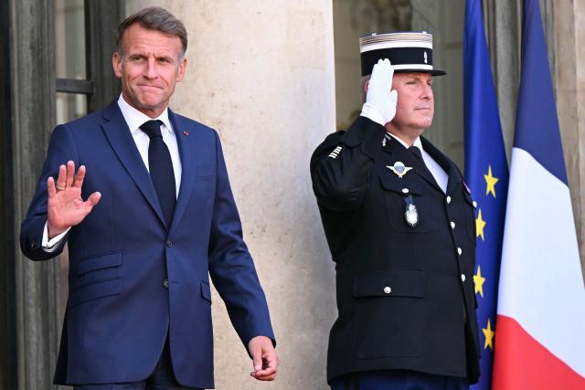 France's President Emmanuel Macron waves as he awaits the arrival of Saudi Arabia's Crown Prince for a meeting at The Elysee Presidential Palace in Paris on August 24, 2026. (Photo by LOU BENOIST / AFP)