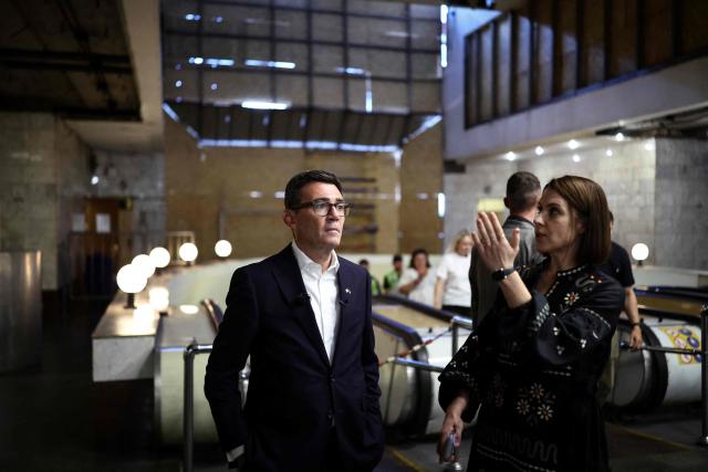 Britain's Prime Minister Andy Burnham (L) reacts as he is shown the boarded windows following strikes at the metro station Lukanivska, in Kyiv, on August 24, 2026, during his first trip abroad since taking office. The United Kingdom will keep providing defence aid to Ukraine despite Russia's threats, Prime Minister Andy Burnham said on August 24, 2026 on a visit to Kyiv where allies gathered to discuss support. Air defence supplies are due to be the main priority at the meeting of the Coalition of the Willing, jointly chaired by the leaders of France and Germany, who will participate remotely, and by Britain's Burnham. (Photo by Henry NICHOLLS / POOL / AFP)