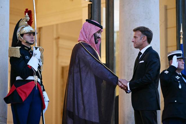 France's President Emmanuel Macron (R) welcomes Saudi Arabia's Crown Prince Mohammed bin Salman as he arrives for a State diner in his honour at the Elysee Palace in Paris on August 24, 2026. (Photo by LOU BENOIST / AFP)