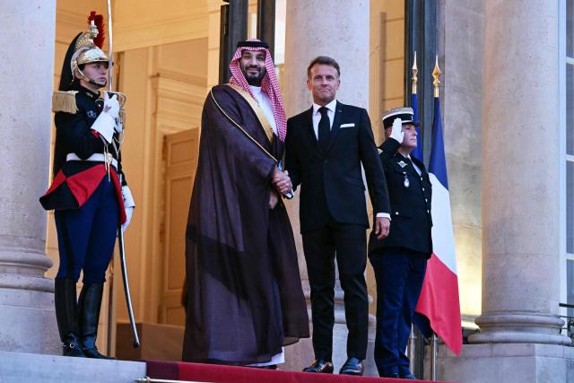 France's President Emmanuel Macron (R) welcomes Saudi Arabia's Crown Prince Mohammed bin Salman as he arrives for a State diner in his honour at the Elysee Palace in Paris on August 24, 2026. (Photo by LOU BENOIST / AFP)