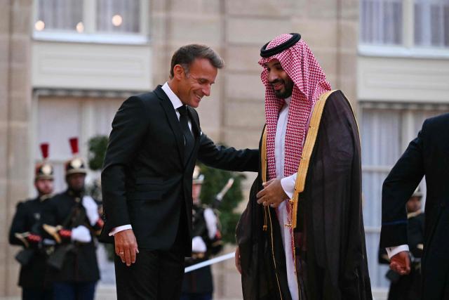 France's President Emmanuel Macron (L) welcomes Saudi Arabia's Crown Prince Mohammed bin Salman as he arrives for a State diner in his honour at the Elysee Palace in Paris on August 24, 2026. (Photo by LOU BENOIST / AFP)