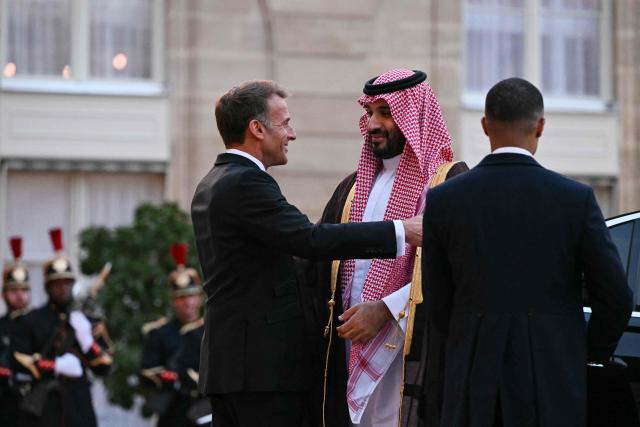 France's President Emmanuel Macron (L) welcomes Saudi Arabia's Crown Prince Mohammed bin Salman as he arrives for a State diner in his honour at the Elysee Palace in Paris on August 24, 2026. (Photo by LOU BENOIST / AFP)