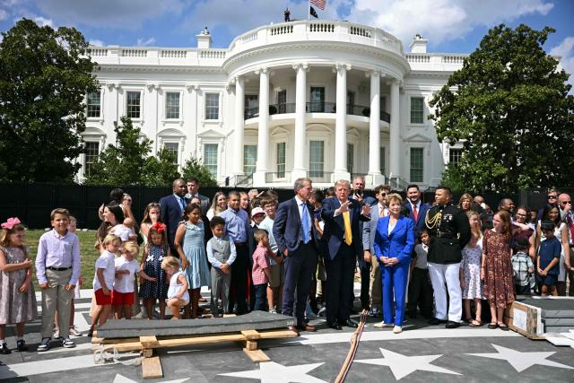 US President Donald Trump (C) speaks with Nebraska Governor Jim Pillen (L) and Secretary of Education Linda McMahon (R) at the construction site of a helipad on the South Lawn of the White House in Washington, DC, on August 24, 2026. (Photo by Jim WATSON / AFP)