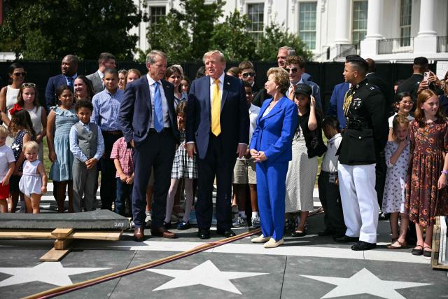 US President Donald Trump speaks with Nebraska Governor Jim Pillen (L) and Secretary of Education Linda McMahon (R) at the construction site of a helipad on the South Lawn of the White House in Washington, DC, on August 24, 2026. (Photo by Jim WATSON / AFP)