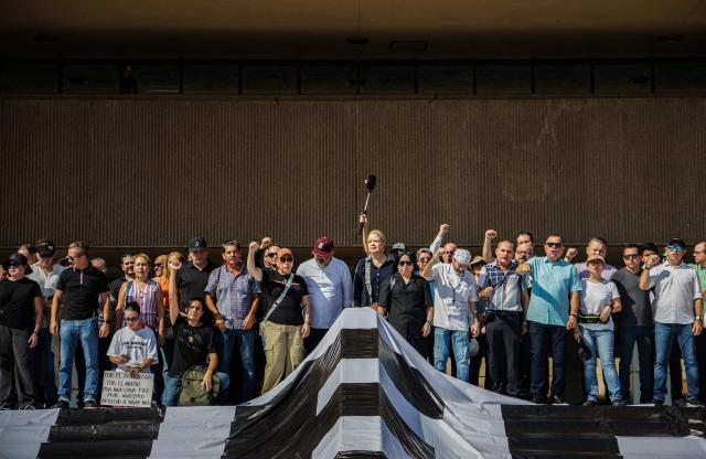 People gather during a protest against Sinaloa state Governor Ruben Rocha Moya at the Government Palace in Culiacan, Sinaloa state, Mexico on August 24, 2026. Mexico's President Claudia Sheinbaum ruled out on August 24, 2026, the return of the ruling-party governor, accused of drug trafficking by the US, to his post in the state of Sinaloa, following a brief attempt to resume office. (Photo by Jesus Verdugo / AFP)