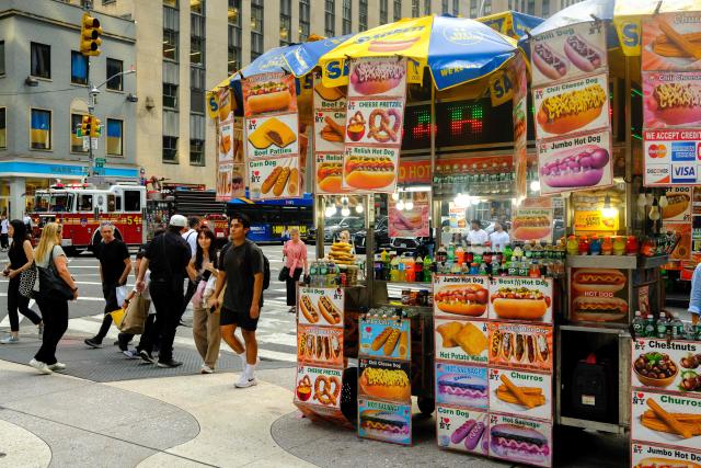 People walk past a hot dog stand on Sixth Avenue in the Manhattan borough of New York City on August 24, 2026. (Photo by CHARLY TRIBALLEAU / AFP)