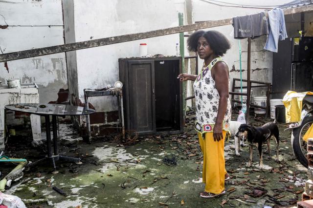 A woman shows her earthquake-damaged home in Buenaventura, Valle del Cauca department, Colombia, on August 24, 2026, two weeks after a magnitude 7.4 earthquake struck the area. (Photo by Cesar QUEIROZ / AFP)